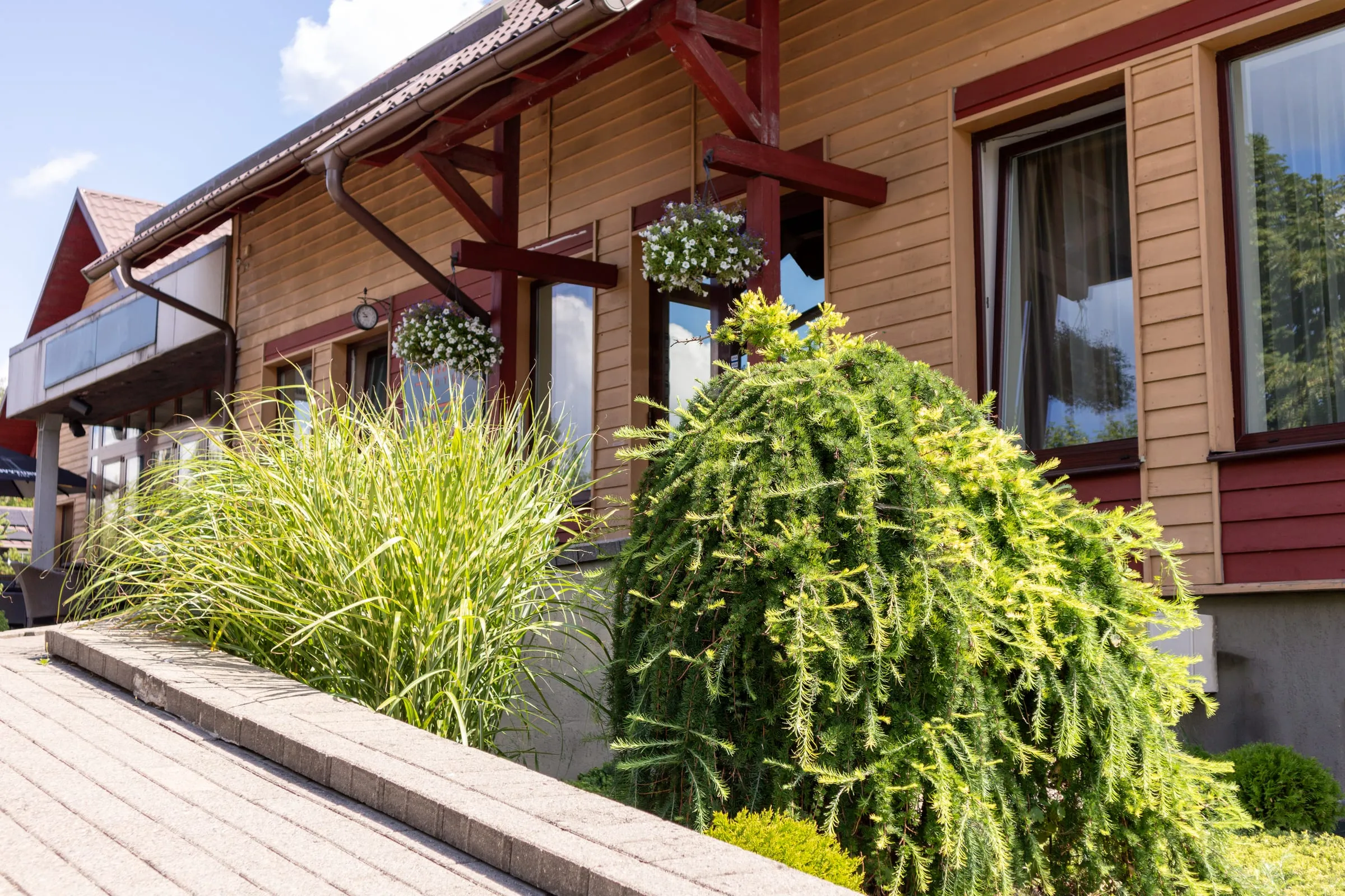 Fachada de una casa de madera con jardín de arbustos