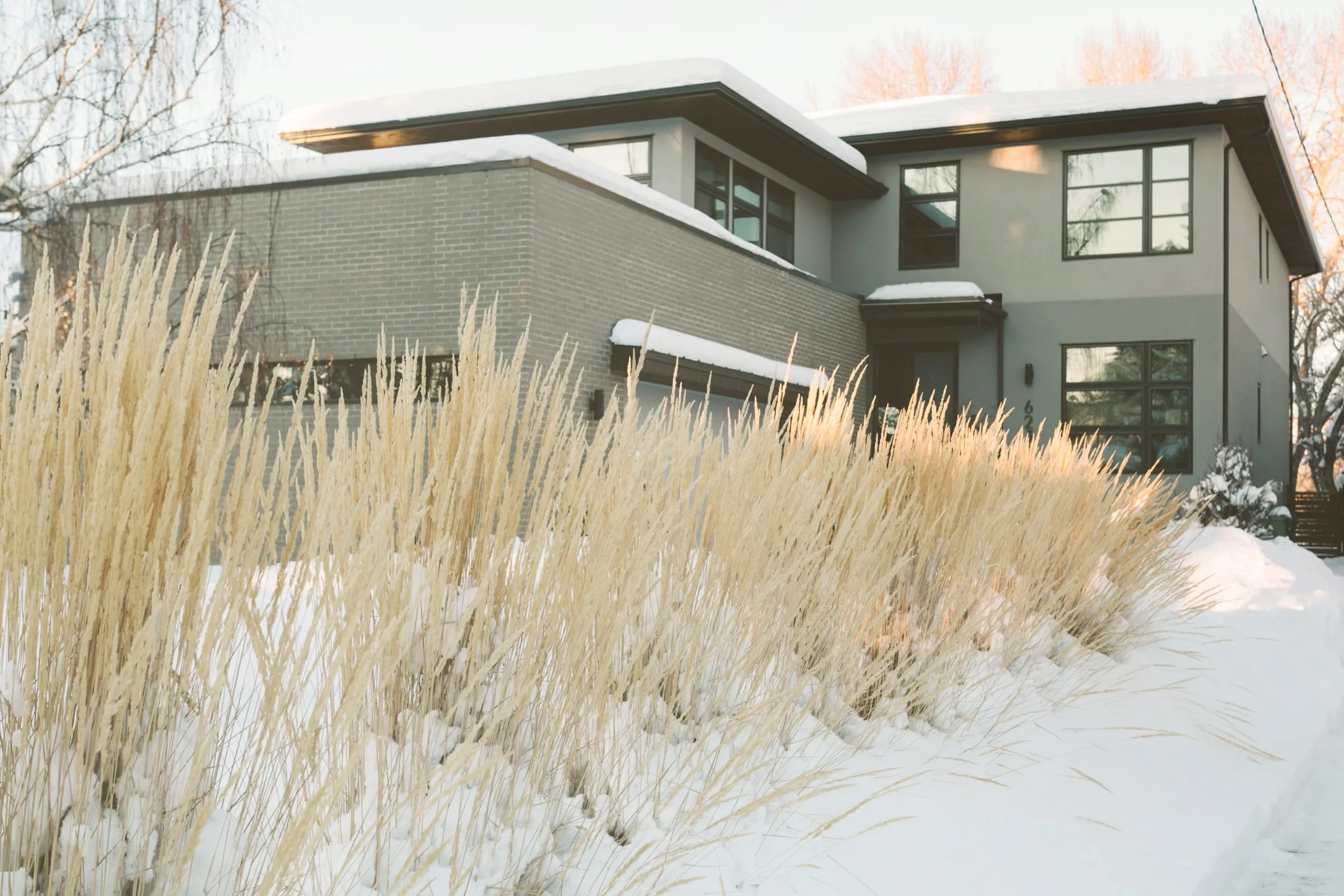 Casa moderna de dos plantas con el jardín nevado en invierno