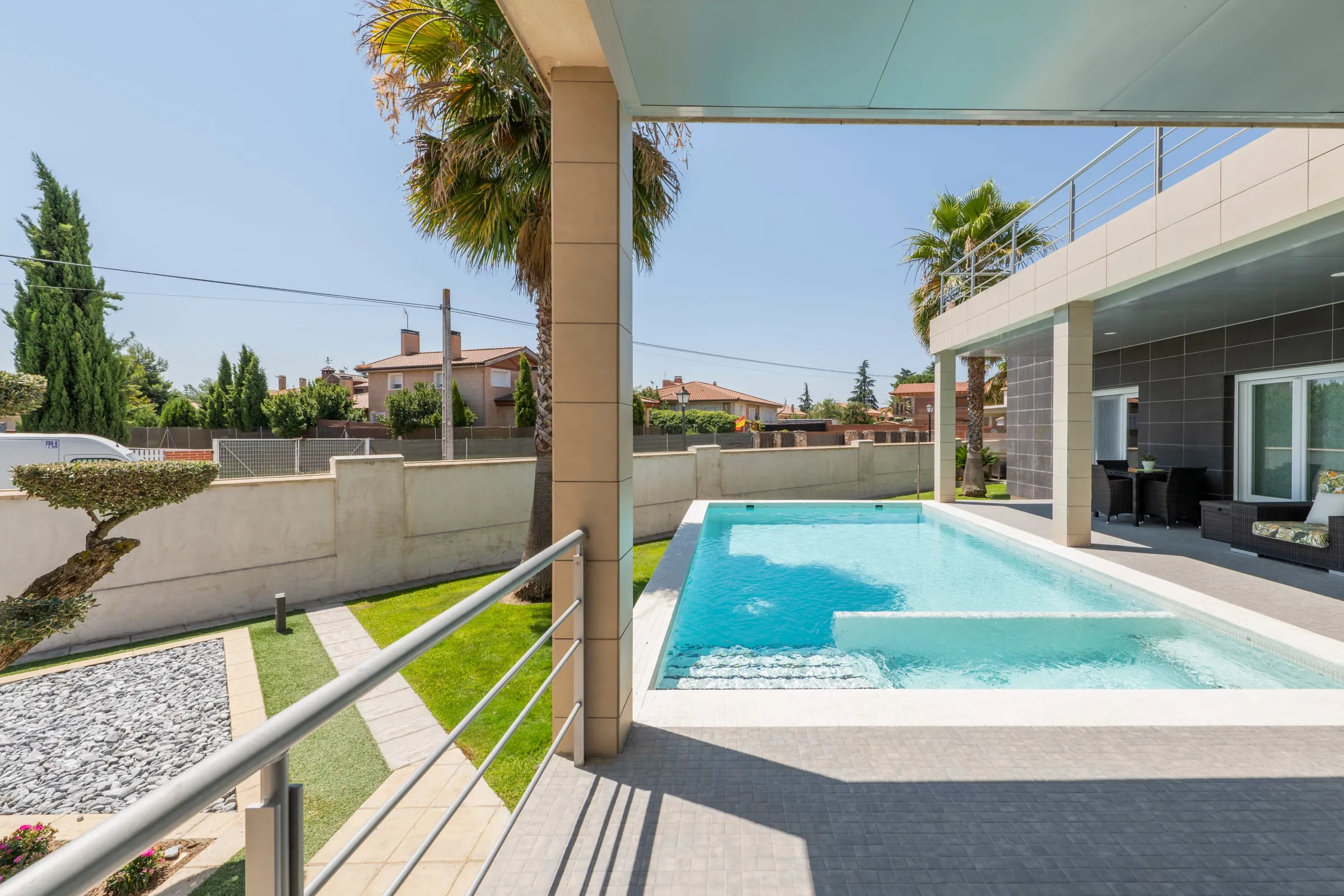 Porche de una vivienda moderna con piscina y jardín