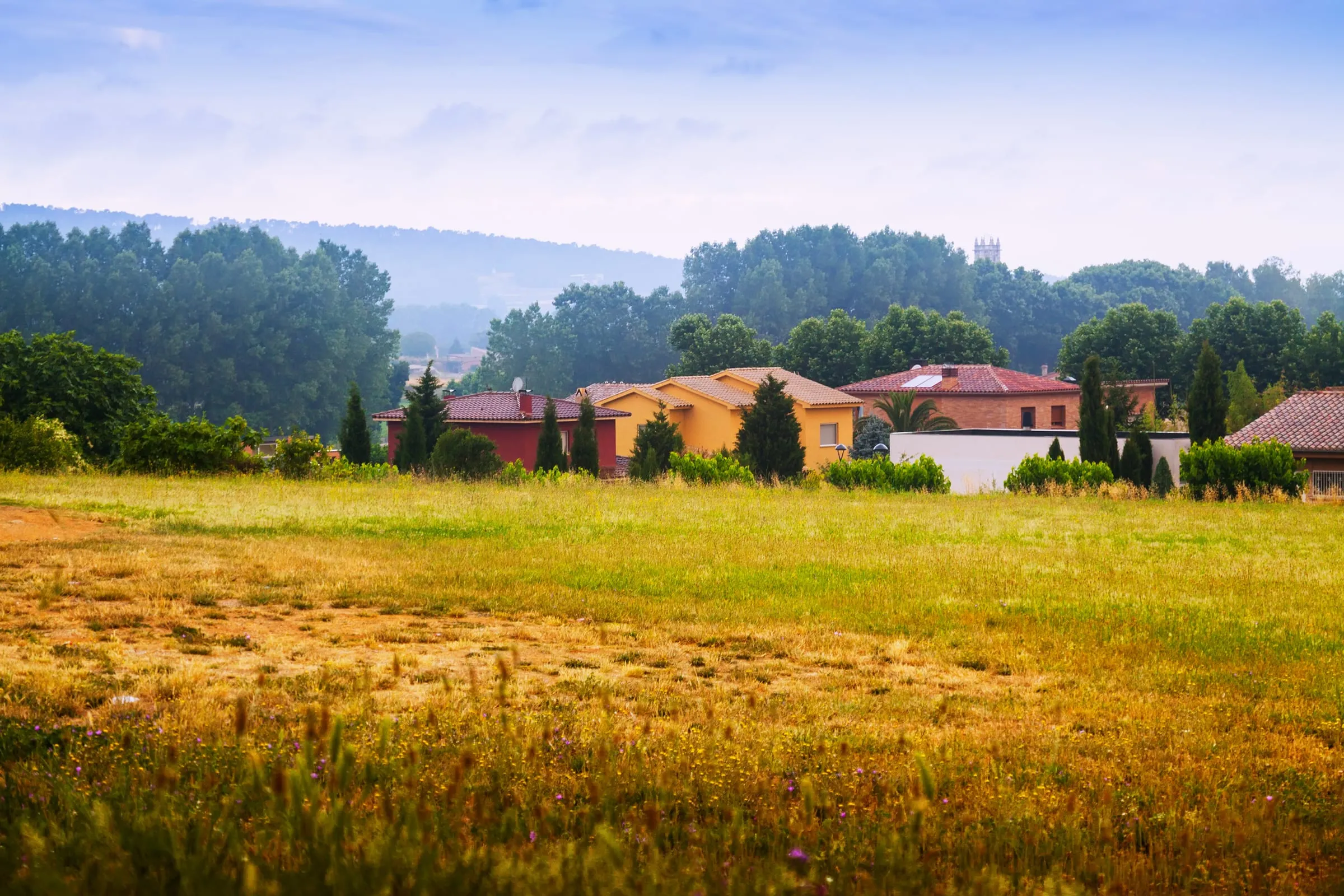 Casas entre prados y pinos en el campo catalán