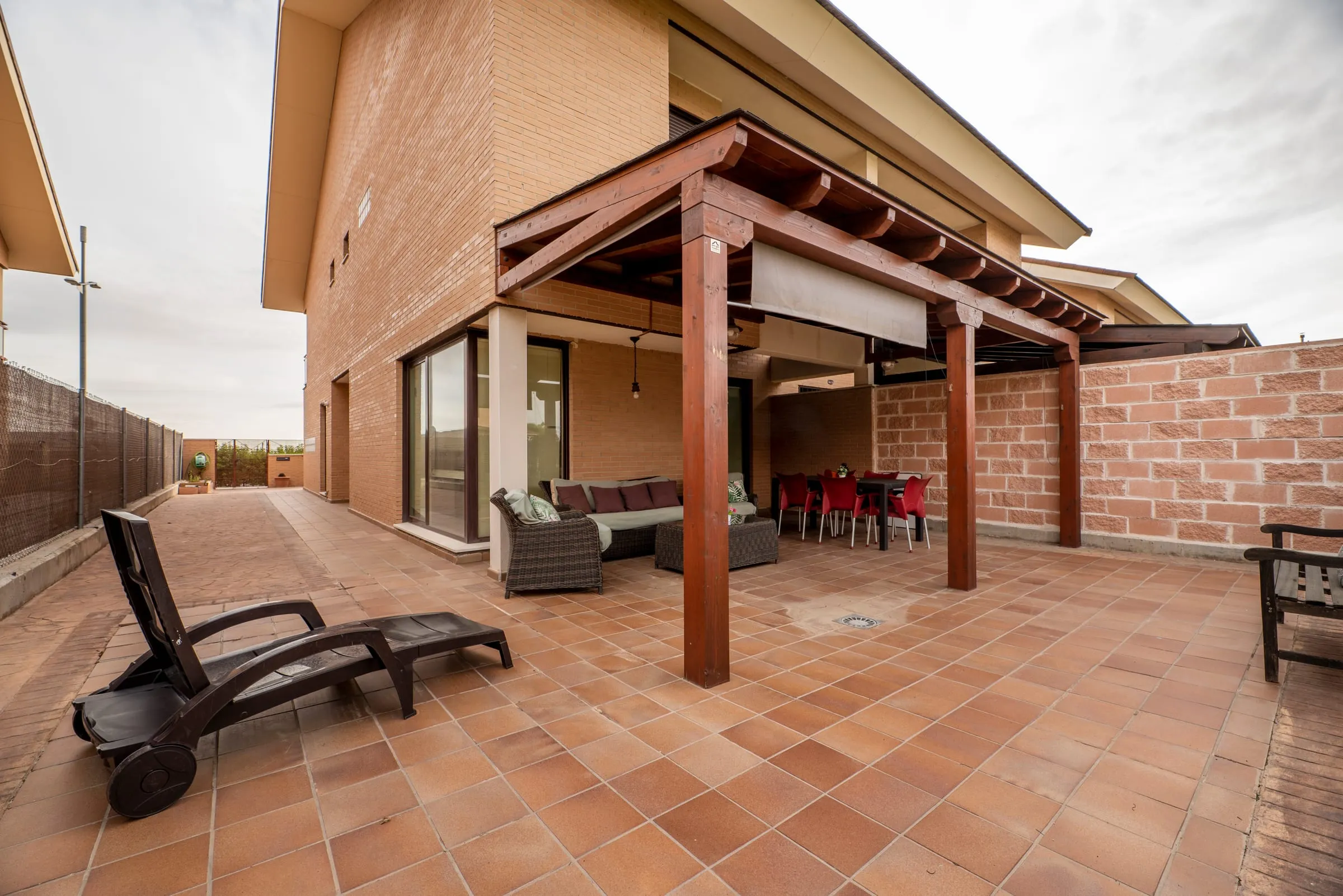 Terraza de un chalet de ladrillo con porche de madera
