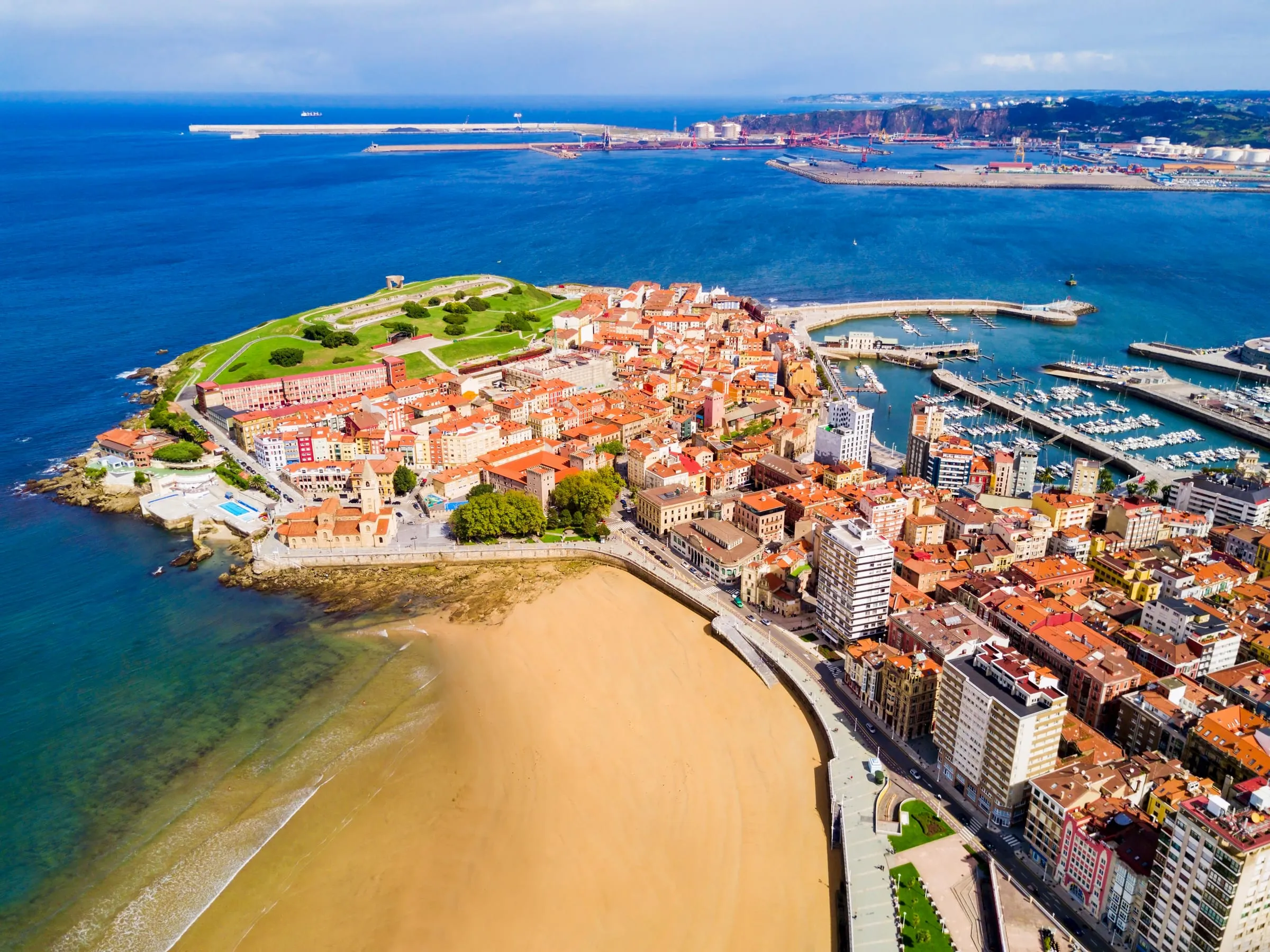 Vista aérea de Gijón: el cerro de Cimadevilla, el puerto deportivo y la playa